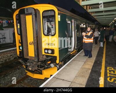 Samedi 20 novembre 2021 - le premier train de la ligne Dartmoor arrive à la gare d'Okehampton.Un service régulier de transport de passagers à Exeter a été inauguré après un écart de près de 50 ans.Pour renouveler la voie, 11 milles de nouvelle voie ont été posés, avec 24,000 traverses en béton, et 29,000 tonnes de balast.Le rétablissement du service régulier améliorera les liens pour les navetteurs et fournira un terminal pour les visiteurs qui pourront explorer le parc national de Dartmoor.Il stimulera les entreprises locales, le secteur du tourisme et offrira un meilleur accès au travail et à l'éducation pour les locaux. Banque D'Images