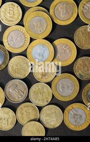 Mélange de monnaie indienne roupie de couleur dorée à l'étage rustique.Plein format.Vue du dessus de la table.Verticale.Financement des entreprises et investissement financier Backgr Banque D'Images