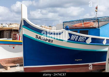 Gros plan d'un bateau de pêche Luzzu traditionnel aux couleurs vives sur le quai du port de Marsaxlokk, Malte, Europe Banque D'Images