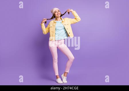 Photo de taille de corps pleine longueur de charmante fille ludique faisant des picots avec les cheveux isolés sur fond violet de couleur Banque D'Images