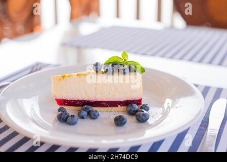 dessert cheesecake sur une assiette avec myrtilles a dans un restaurant avec une feuille de menthe Banque D'Images