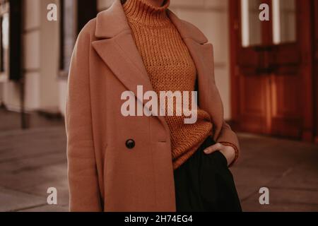 Coupe courte pour femme, chaude et marron, avec pull orange en maille.Street décontracté hiver ou automne mode. Banque D'Images