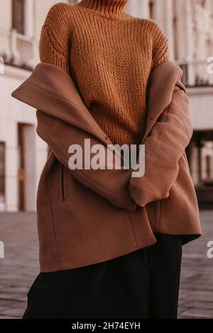 Coupe courte pour femme, chaude et marron, avec pull orange en maille.Street décontracté hiver ou automne mode. Banque D'Images