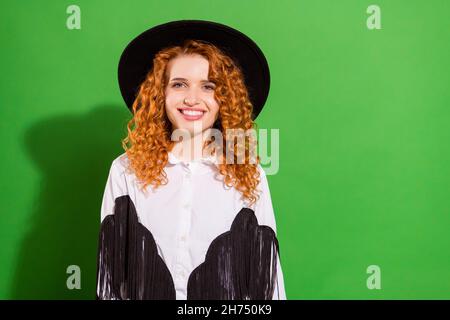 Portrait d'une jolie jeune fille à poil ondulé, vêtue d'un cow-boy moderne et cool, isolée sur fond vert vif Banque D'Images