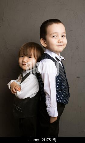 Deux petites sœurs asiatiques heureuses et frère regardant l'appareil photo Banque D'Images