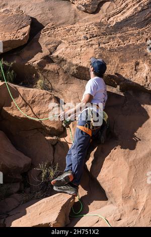 Un grimpeur survit un autre grimpeur sur la route d'escalade au-dessus de lui près de Moab, Utah. Banque D'Images