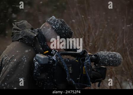 Caméra opérateur filmant dans la neige avec une caméra vidéo Panasonic P2 Banque D'Images