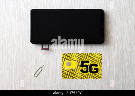 Remplacement d'une carte SIM 4G par une carte à haut débit de 5 g. Carte SIM en gros plan sur la table en bois du magasin Banque D'Images