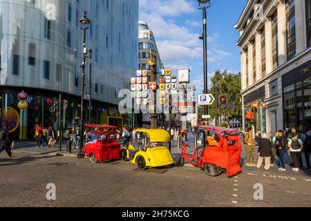 Taxis à vélo colorés garés dans Wardour Street à l'entrée de Leicester Square dans le West End de Londres Banque D'Images