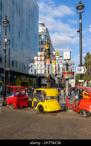 Taxis à vélo colorés garés dans Wardour Street à l'entrée de Leicester Square dans le West End de Londres Banque D'Images