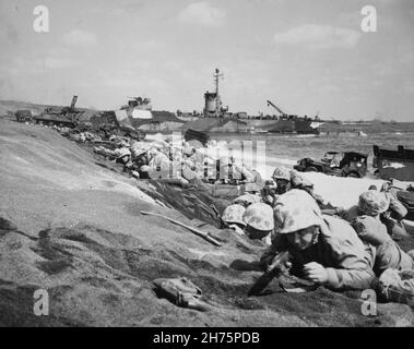 IWO JIMA, OCÉAN PACIFIQUE - 19 février 1945 - les Marines américaines sont épinglées par un feu japonais sur une plage d'atterrissage le jour J de la bataille d'Iwo Jima.Ces beac Banque D'Images