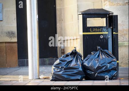 Envolez-vous pour le basculement des déchets et des sacs poubelle noirs dans un quartier résidentiel Banque D'Images