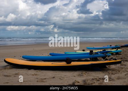 Planches de surf d'une école de surf à la plage de soulac-sur-mer à l'océan atlantique en France avec mer ondulée et ciel dramatique en arrière-plan Banque D'Images