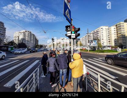 Bucarest, Roumanie - 18 novembre 2021: Les gens attendent de traverser la rue dans la station de tramway de Piata Iancului. Banque D'Images