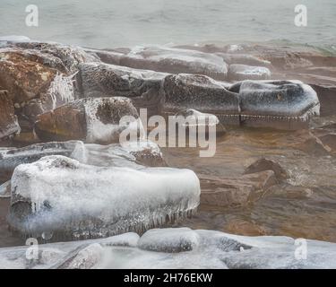 En hiver, les vagues de gel forment des glaçons miniatures sur les rochers le long du lac supérieur Banque D'Images