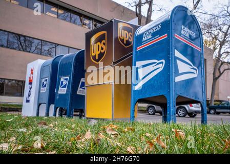Fort Collins, CO, le 9 novembre 2021: Gare de dépôt de colis et de lettres - bureau de poste des États-Unis, boîtes de dépôt FedEx et UPS au stationnement du bureau. Banque D'Images