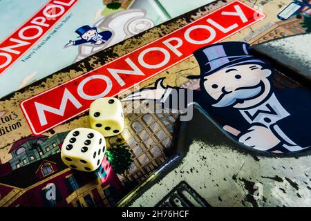 Monopoly Board Game gros plan avec la boîte, le plateau et les dés.Le jeu de commerce immobilier classique de Parker Brothers a été introduit pour la première fois en Amérique Banque D'Images