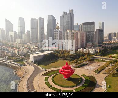 21 novembre 2021 - Qingdao, Chine: Mai quatrième sculpture de vent sur la quatrième place de mai.Gratte-ciel et soleil en arrière-plan; Banque D'Images