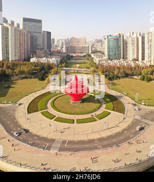 21 novembre 2021 - Qingdao, Chine: Mai quatrième sculpture de vent sur la quatrième place de mai.Gratte-ciel et soleil en arrière-plan; Banque D'Images