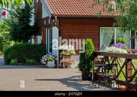 Petit cottage décoré avec des fleurs de pétunia par une belle journée d'été. Banque D'Images