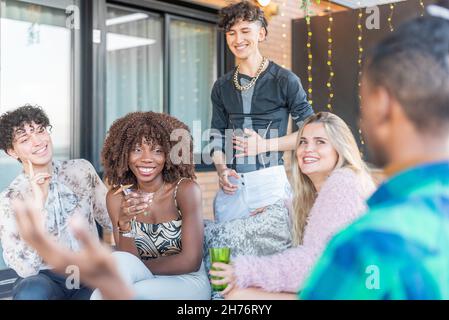 Amis multiethniques célébrant la Saint-Sylvestre sur une terrasse Banque D'Images