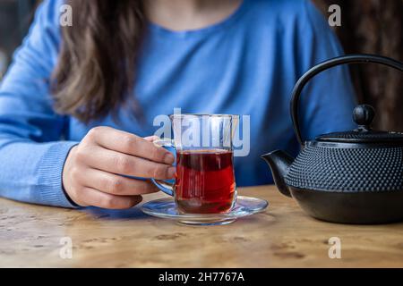 Gros plan sur la théière en fonte texturée noire et thé. Banque D'Images