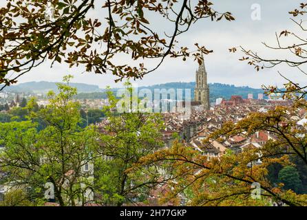 Vue sur la ville médiévale de Berne, capitale de la Suisse, avec un premier plan d'arbres et ciel nuageux en arrière-plan. Banque D'Images