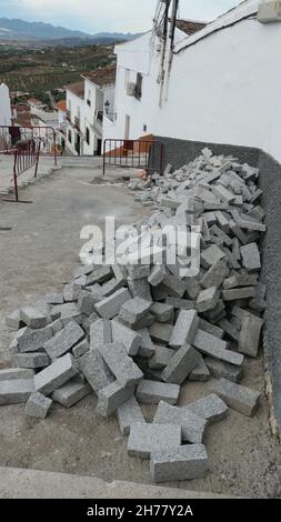 Pile de petits pavés oblongs en granit prêts à poser sur le chemin du village Banque D'Images