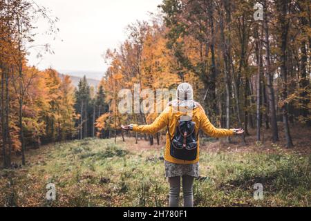 Femme de randonnée appréciant l'air frais et se sentant l'énergie positive dans la forêt d'automne.S'éloigner de tout.Détox numérique dans la nature Banque D'Images