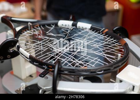 Processus d'accrocher une raquette de tennis dans un magasin de tennis, nouvelle corde de raquette de tennis, sport et concept de loisirs Banque D'Images