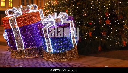 POLOGNE, BYDGOSZCZ - 30 décembre 2020 : cadeaux décoratifs des guirlandes sous l'arbre de Noël.Ville festive nocturne à la veille du nouvel an Banque D'Images