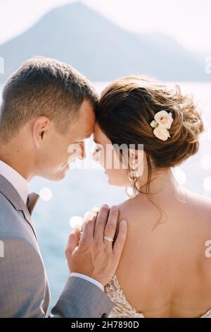 Le marié pencha son front contre le front de la mariée et mit sa main sur son épaule Banque D'Images