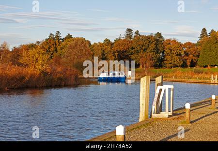 Un croiseur arrondissant un virage sur la rivière Ant en automne sur les Norfolk Broads à Ludham, Norfolk, Angleterre, Royaume-Uni. Banque D'Images