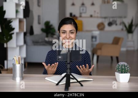 Une jeune femme indienne pleine de sourires et confiante enregistre des vidéos sur un téléphone portable. Banque D'Images