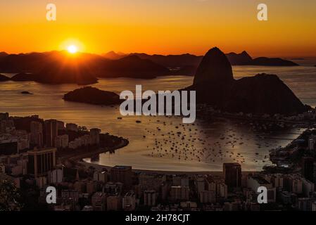 Lever de soleil doré sur la baie de Guanabara à Rio de Janeiro avec le mont Sugarloaf à l'horizon Banque D'Images