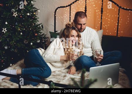 Chandail blanc souriant, homme et femme, discutant sur skype Banque D'Images