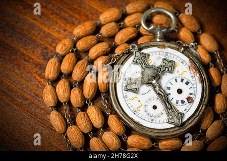 Temps de prier - ancienne montre de poche avec un crucifix d'argent vintage et un rosaire avec des perles de bois Banque D'Images