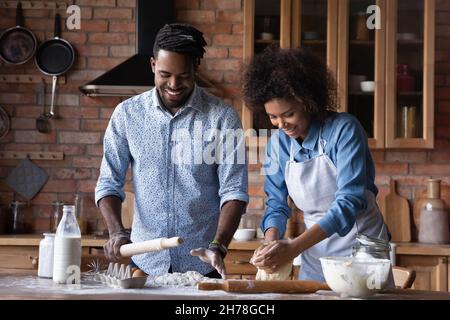 Joyeux amoureux jeune couple afro-américain pâtisserie à la maison. Banque D'Images