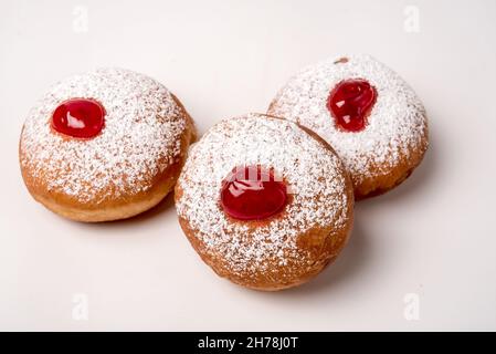 Sufganiyah (sufganiyot) un juif traditionnel Donut mangé pendant Hanoucca avec confiture rouge et le sucre en poudre. Sur fond blanc Banque D'Images