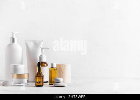 Produits de beauté pour soins de la peau sur table blanche, assortiment de bouteilles de cosmétiques, cosmétologie saine, concept de traitement spa, espace de copie. Banque D'Images