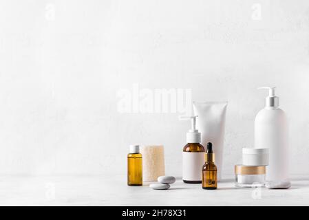 Produits de beauté pour soins de la peau sur table blanche, assortiment de bouteilles de cosmétiques, cosmétologie saine, concept de traitement spa, espace de copie. Banque D'Images