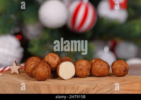 Les bonbons traditionnels allemands de Noël appelés 'Marzipankartoffeln'. Morceaux de pâte d'amandes en forme de boule ronde recouverts de cannelle et de poudre de cacao Banque D'Images