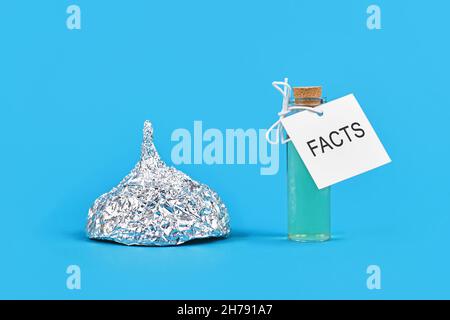 Concept de lutte contre les théories du complot avec des faits avec un chapeau de tinfoil et un flacon de cure avec le mot « faits » Banque D'Images