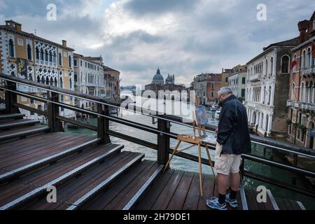 Peintre sur le Ponte dell'Accademia au-dessus du Grand Canal en direction de la Basilique de Santa Maria della Salute à Venise, Italie. Banque D'Images