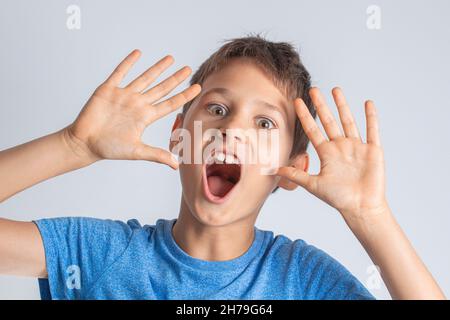 Portrait d'un garçon surpris choqué avec ouverture de la bouche et les mains risées regardant directement à l'appareil photo Banque D'Images