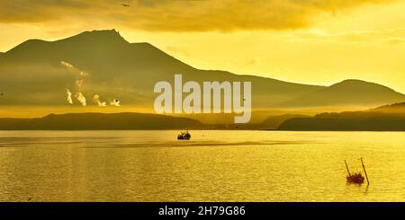 Coucher de soleil d'or sur l'île de Kunashir avec vue sur le volcan actif de Mendeleev.C'est l'île la plus méridionale des îles Kouriles Banque D'Images