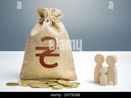 Sac d'argent hryvnia ukrainien avec argent et figurines de famille.Soutien financier aux institutions sociales.Investissements dans le capital humain, la culture et les soci Banque D'Images
