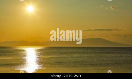 Coucher de soleil doré sur l'île de Kunashir.L'île japonaise Hokkaido est en face à l'horizon.les territoires disputés entre la Russie et le Japon. Banque D'Images