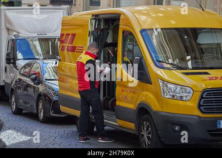 DHL préposé à la livraison de colis attendant devant la camionnette de livraison (Madrid, Espagne). Banque D'Images