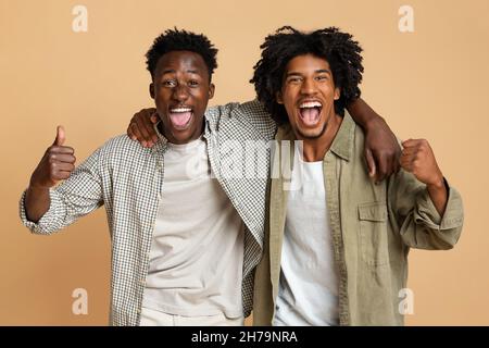 Grande chance.Portrait de deux amis hommes noirs surjoyeux célébrant le succès ensemble Banque D'Images
